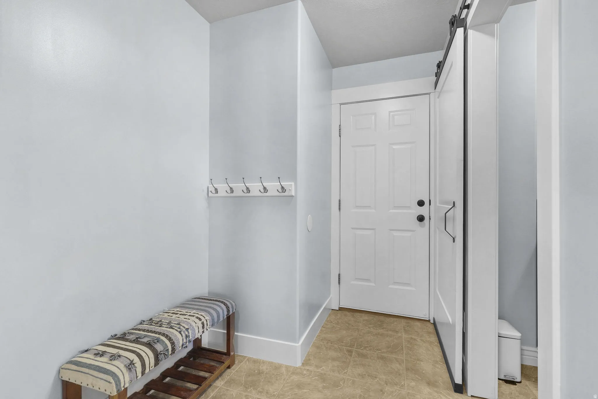 Entryway featuring light-toned walls, tile flooring, and a white six-panel door