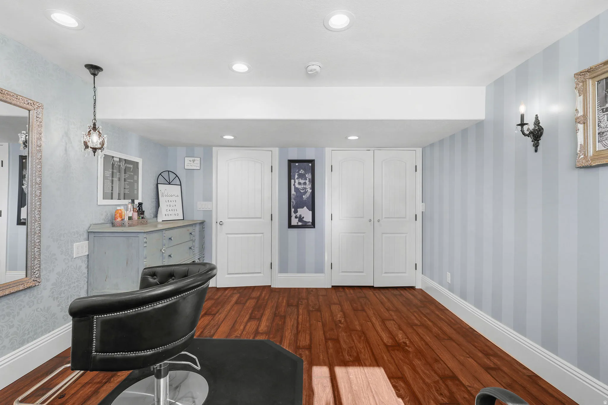 Wood-finish flooring, recessed lighting, and wall-mounted sconces