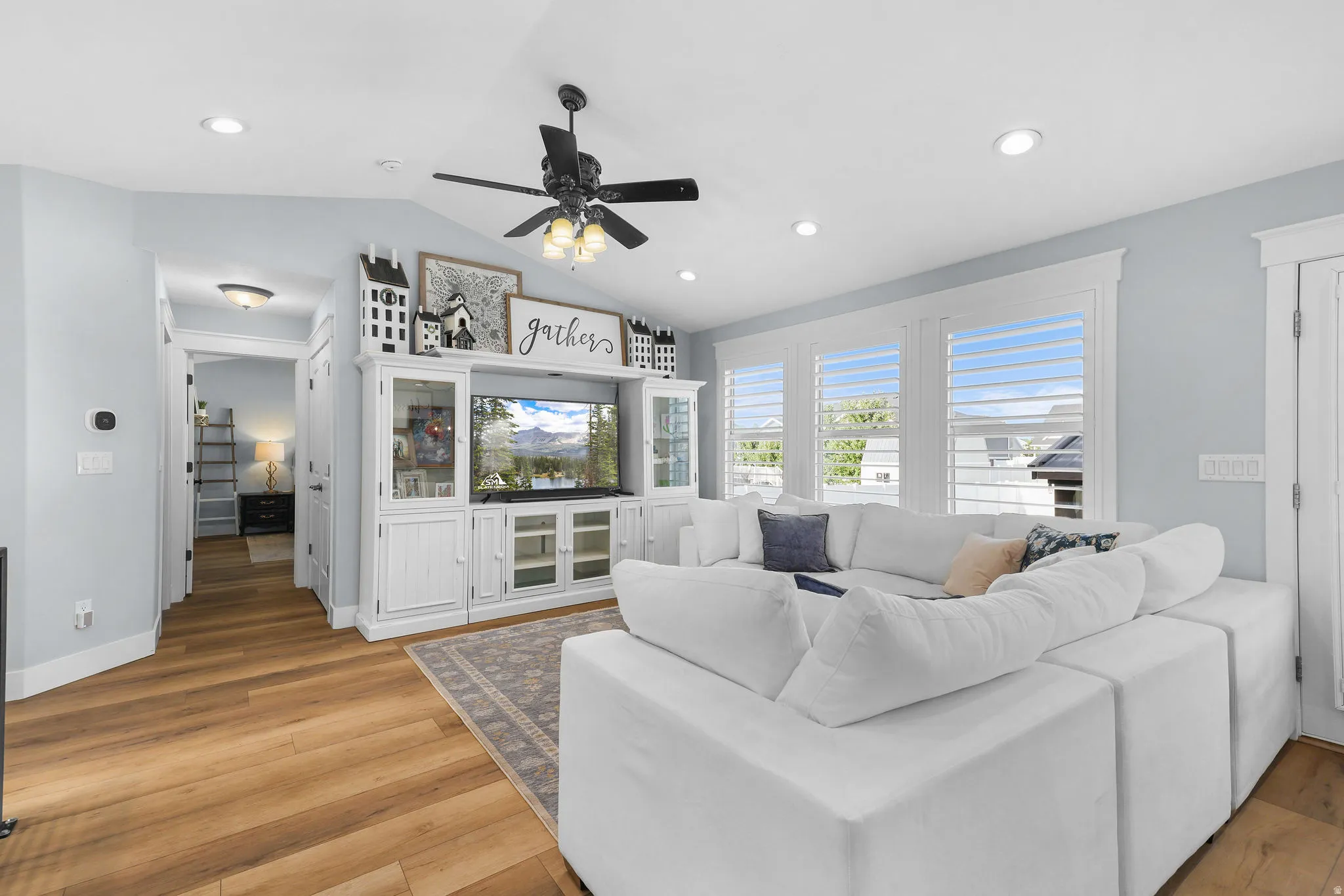 Vaulted ceiling with recessed lighting and a ceiling fan