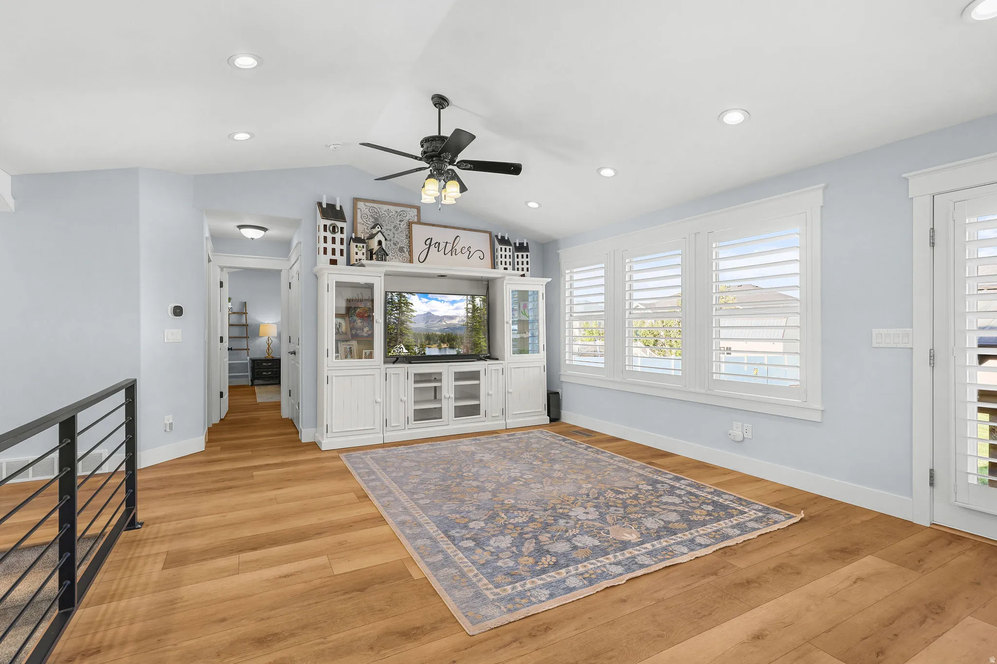 Vaulted ceilings with recessed lighting, wood-finish flooring, and white plantation shutters
