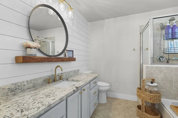 Granite countertop vanity with undermount sink and brass-finish faucet
