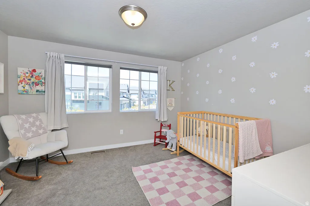 1 of 3 upstairs bedrooms featuring dual windows, light gray wall paint, and a ceiling-mounted flush light fixture