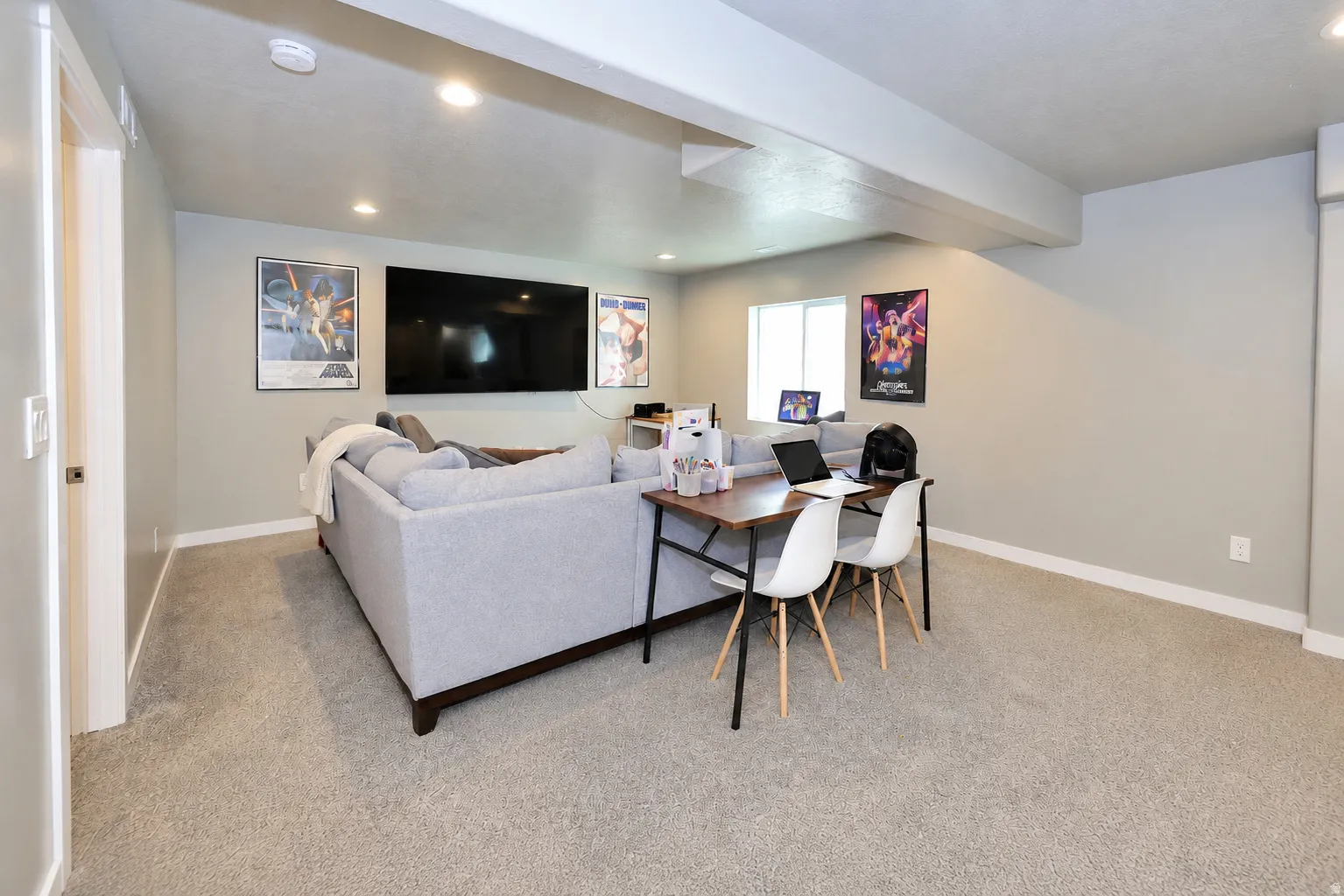 Recessed ceiling lighting, light-toned wall paint, neutral carpeting, and a window for natural illumination