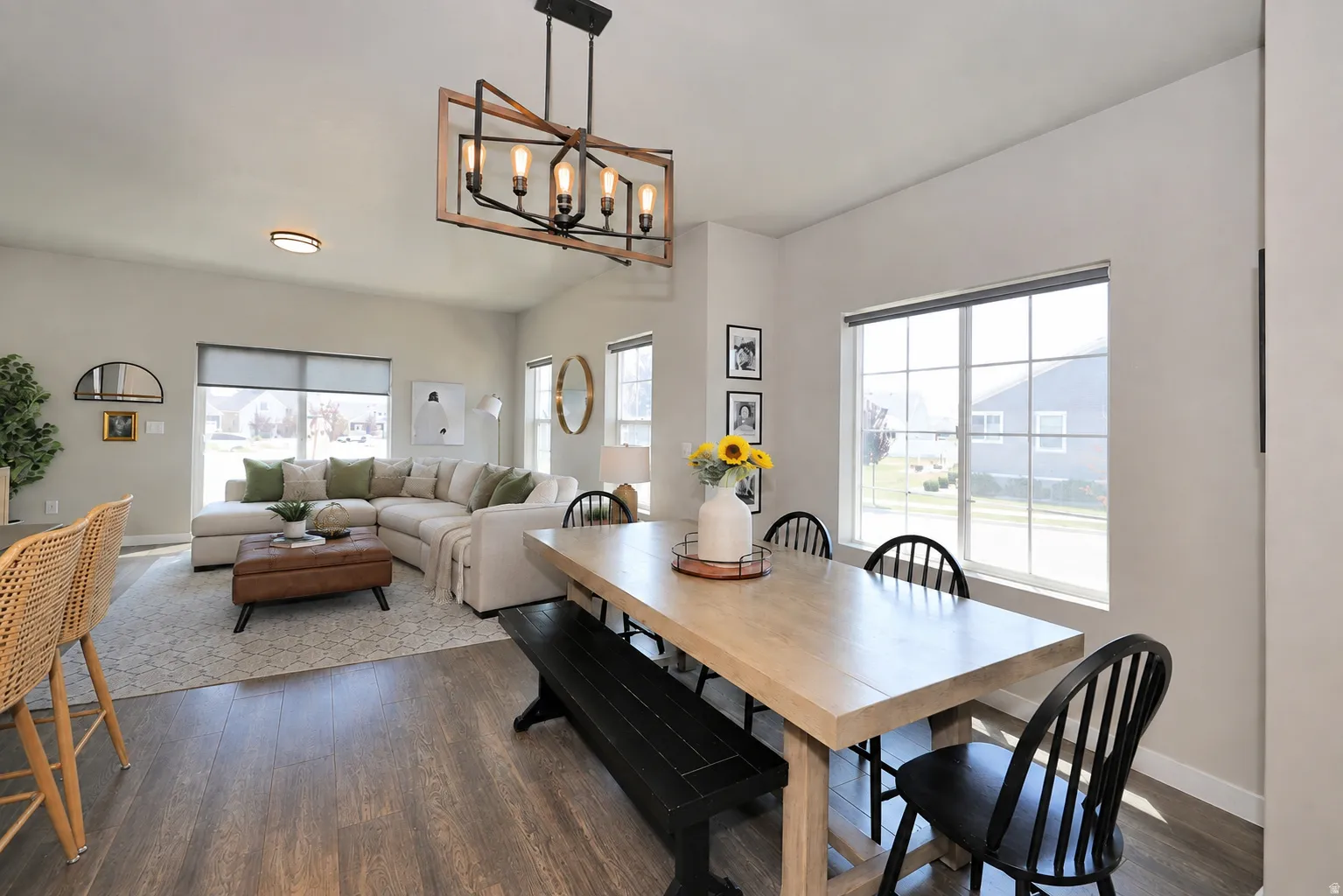 Open-concept living space featuring wood-finish flooring and a vaulted ceiling
