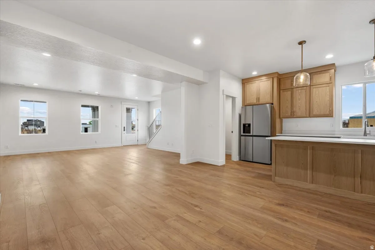 Open-concept living space featuring wood-finish flooring, recessed lighting, and ample natural light from multiple windows