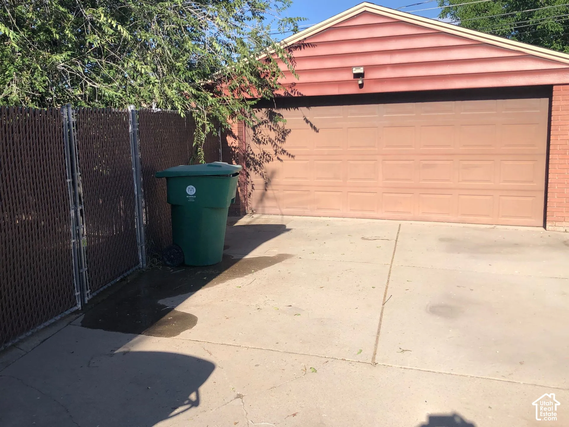 Attached garage with a panel-style door, brick siding, and horizontal siding