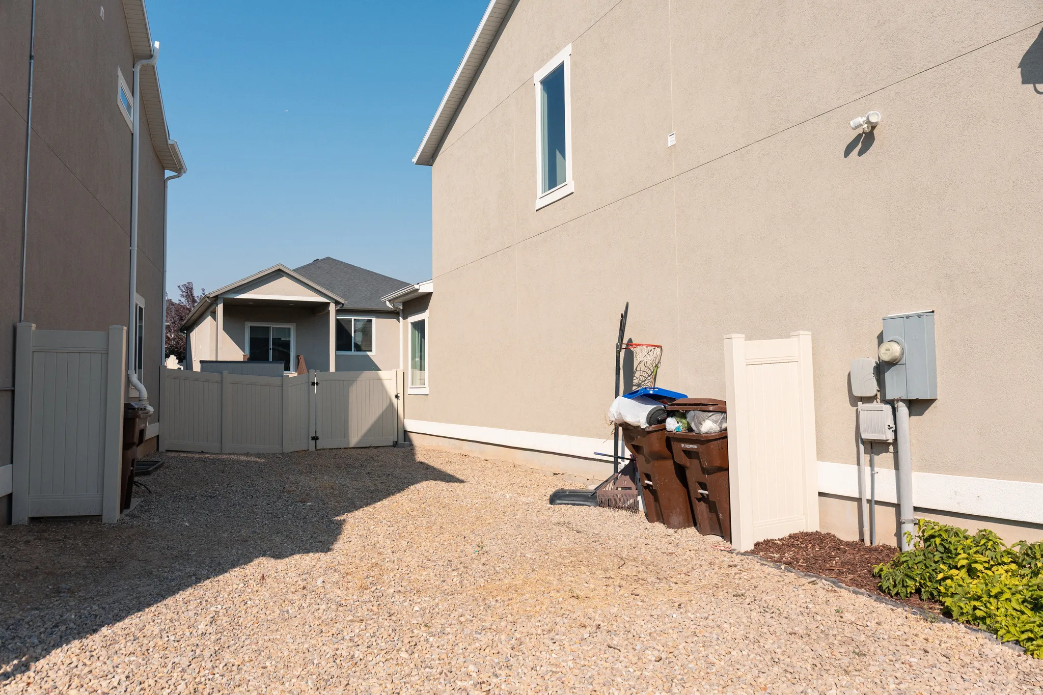 Spacious gravel courtyard with multiple outbuildings including a detached garage and storage shed