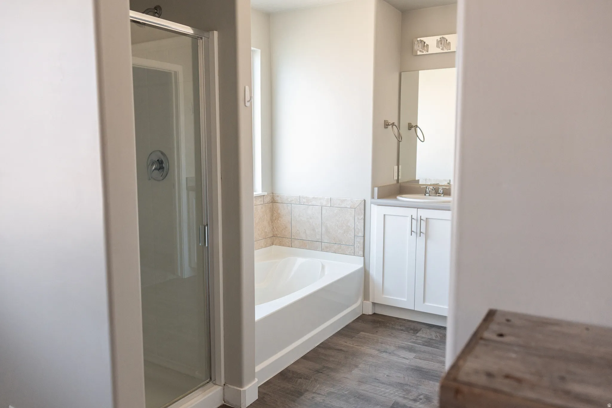 Spa-inspired primary bathroom featuring a freestanding soaking tub, frameless glass shower enclosure, and dual vanity with white cabinetry and brushed nickel hardware