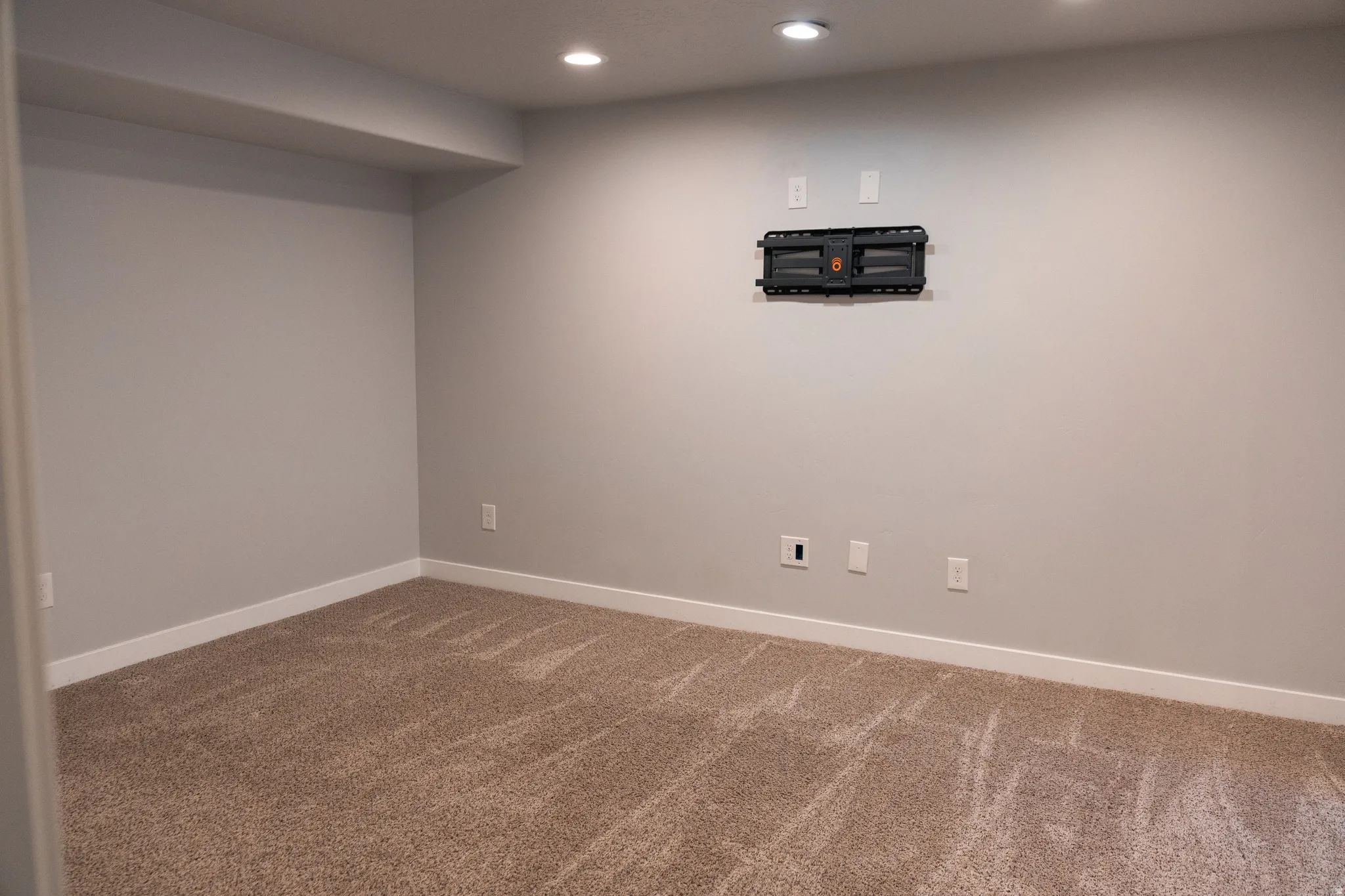 Finished basement featuring neutral walls, recessed ceiling lighting, and neutral-toned carpet flooring throughout
