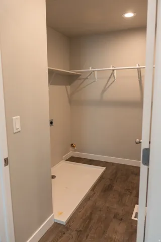 Utility area featuring wood-finish flooring, recessed lighting, and a utility sink base