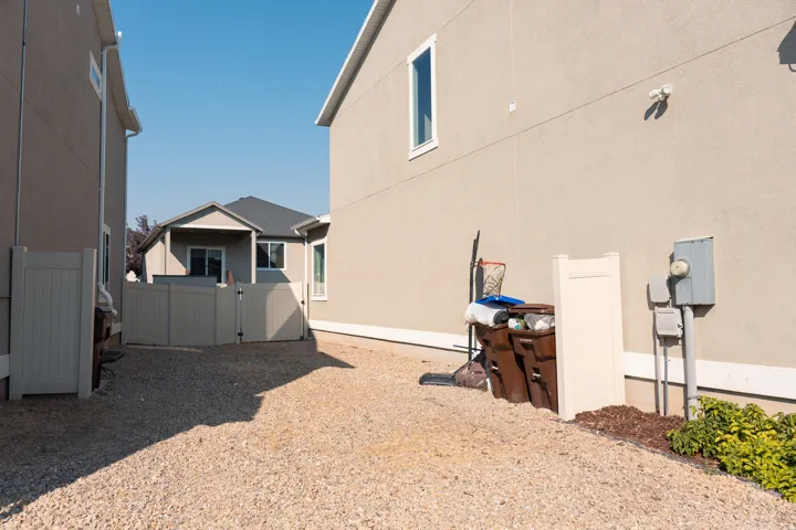 Spacious gravel courtyard with multiple outbuildings including a detached garage and storage shed