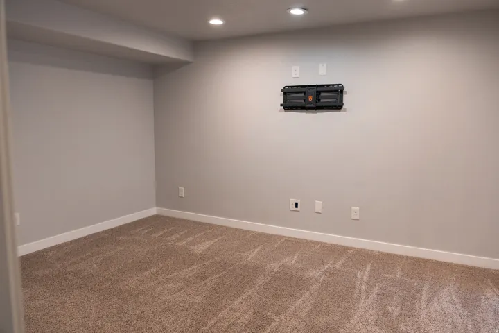 Finished basement featuring neutral walls, recessed ceiling lighting, and neutral-toned carpet flooring throughout