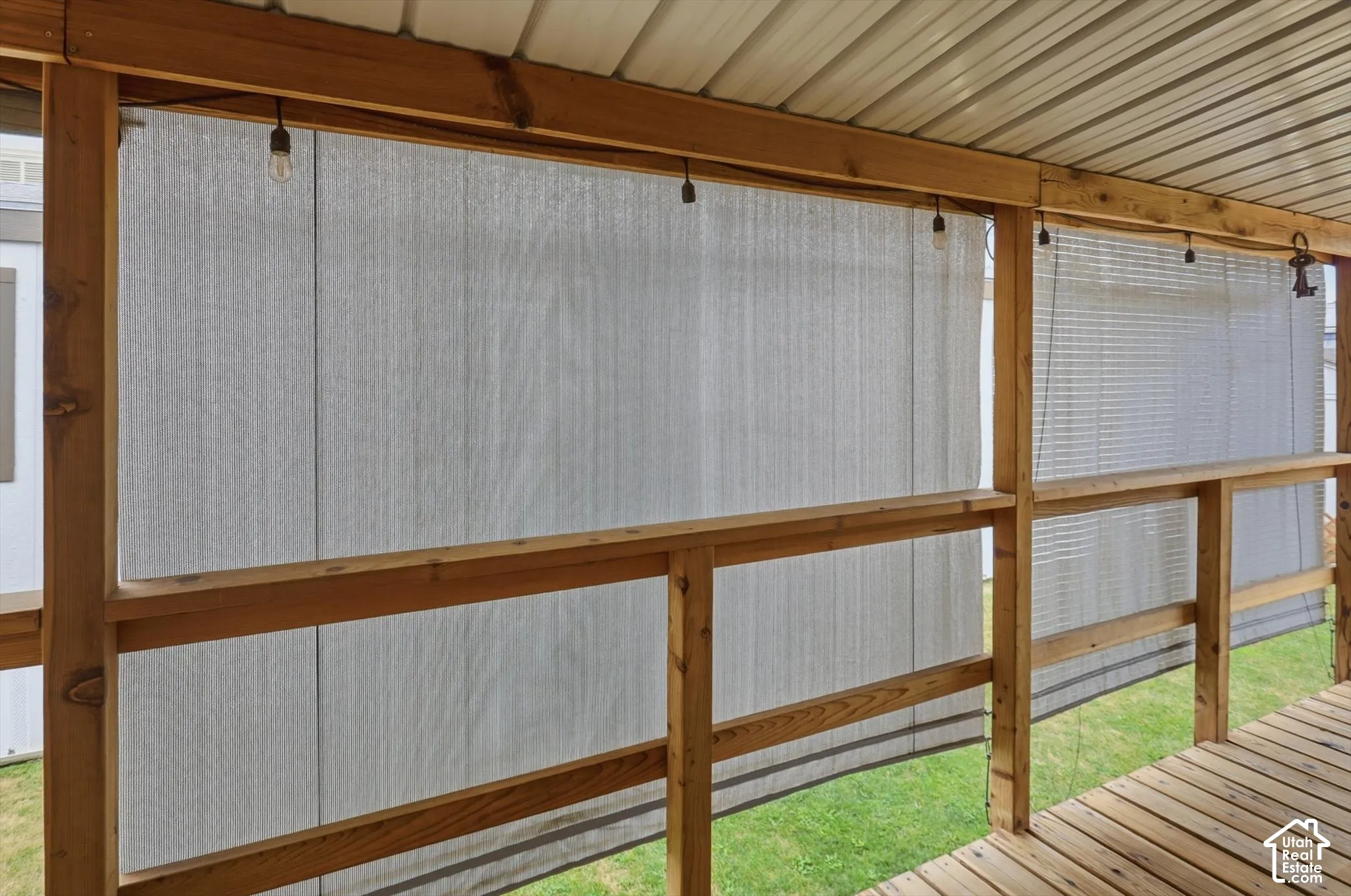 Covered deck with wood flooring, wood railing, and string lighting