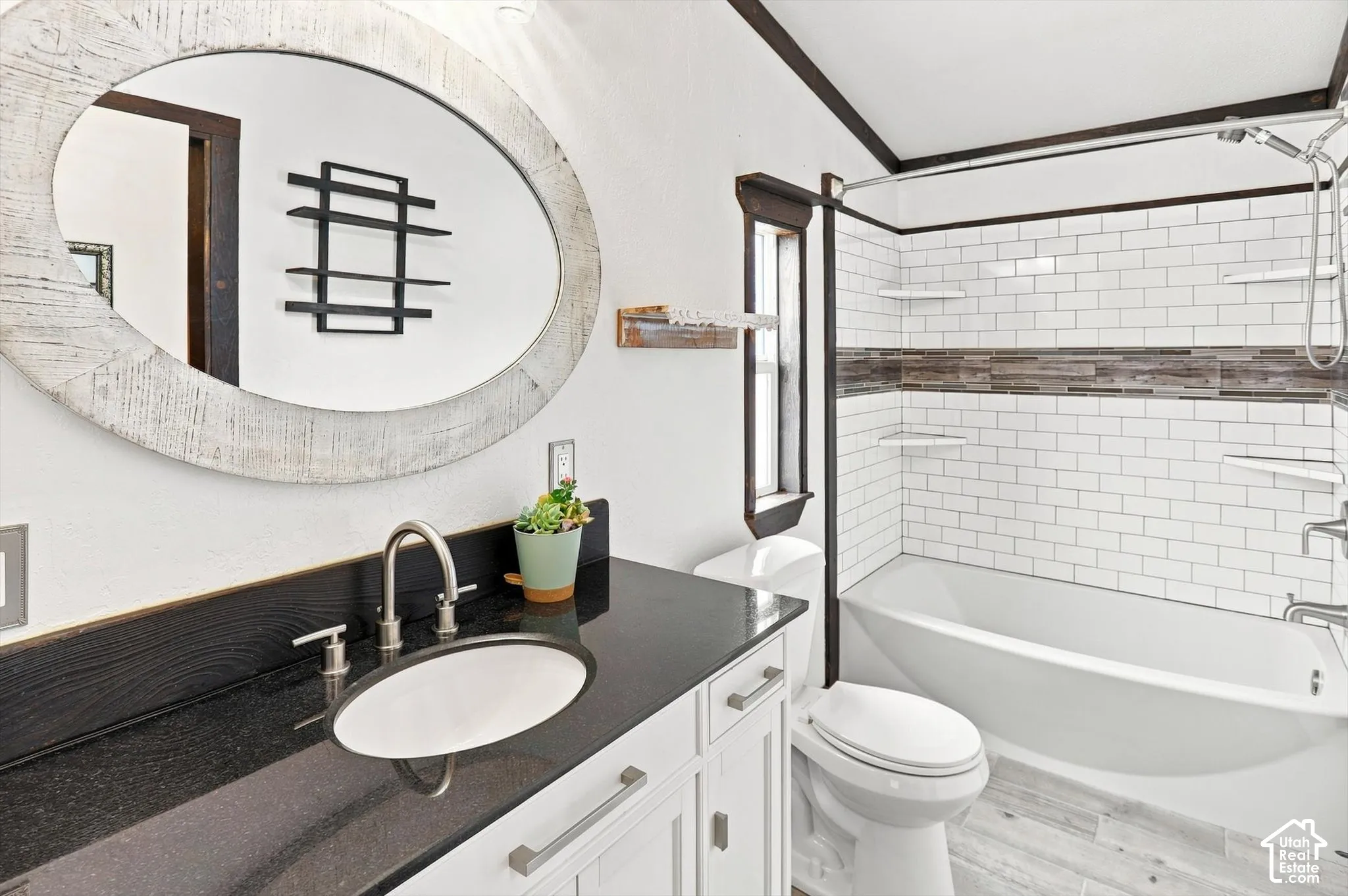 White vanity with brushed nickel hardware, black countertop, and undermount sink