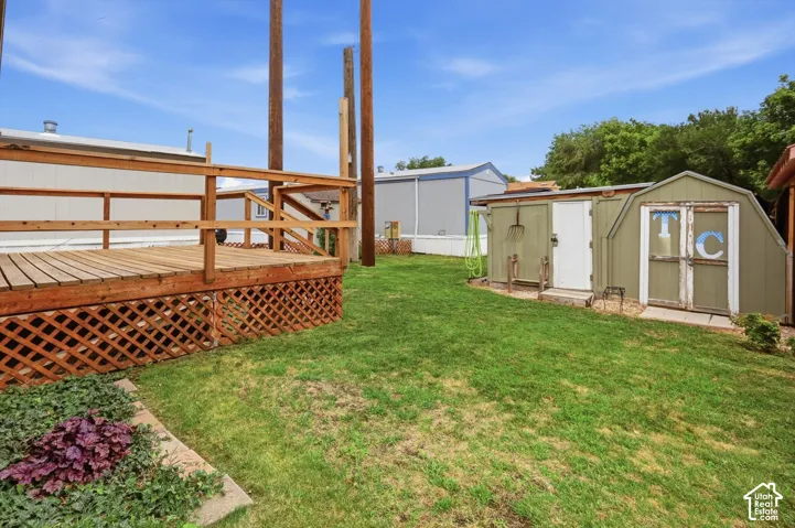 Expansive green lawn with a wood deck featuring lattice skirting