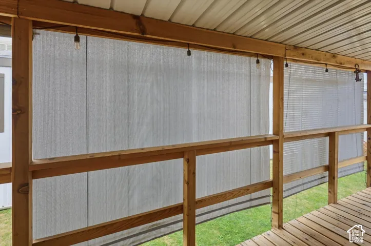 Covered deck with wood flooring, wood railing, and string lighting