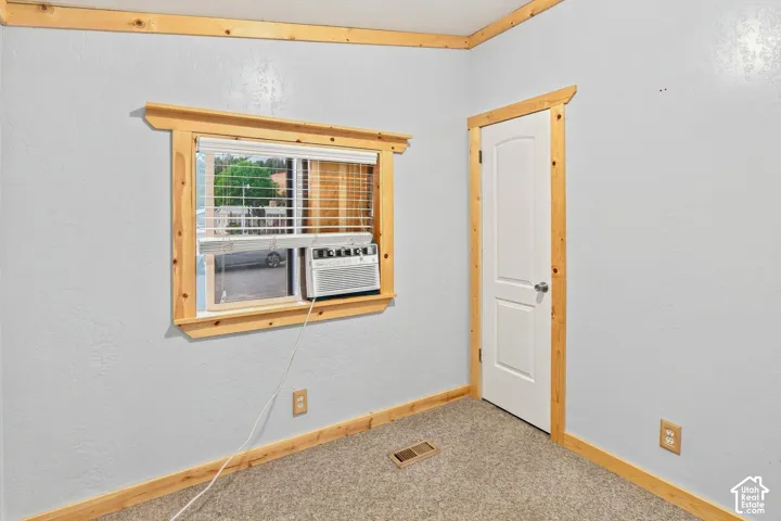 Window with blinds, wood-finish trim, and light gray wall paint