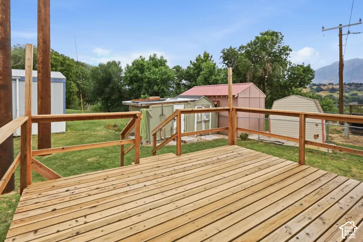 Wood-plank deck with wood railings, overlooking a grassy yard