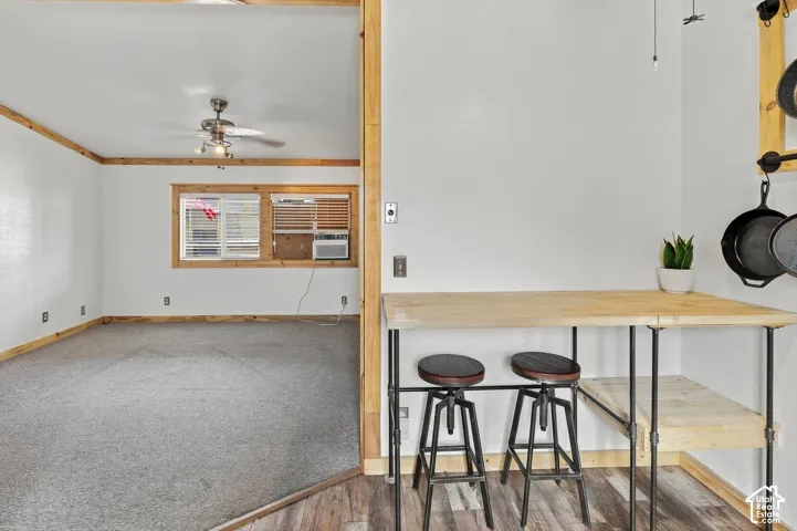Wood-finish flooring with a breakfast bar and pendant lighting