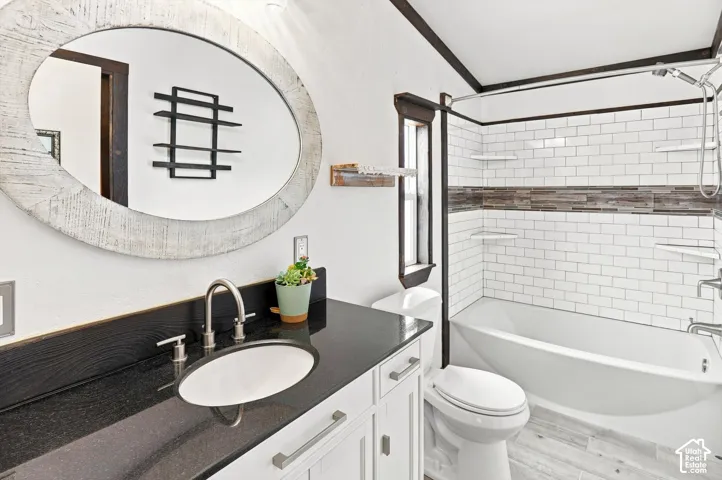 White vanity with brushed nickel hardware, black countertop, and undermount sink