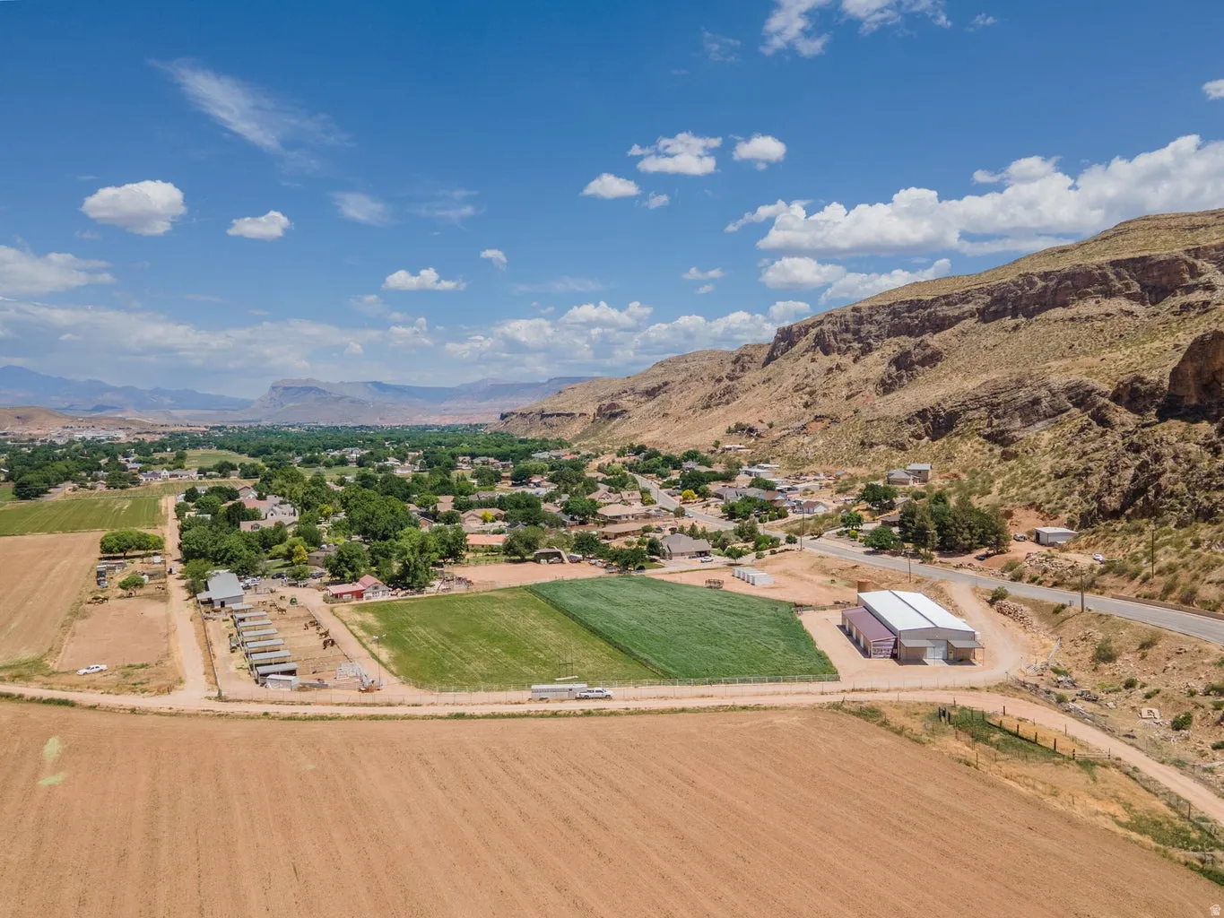 Expansive agricultural lands with established fields, multiple outbuildings, and a prominent commercial-style structure