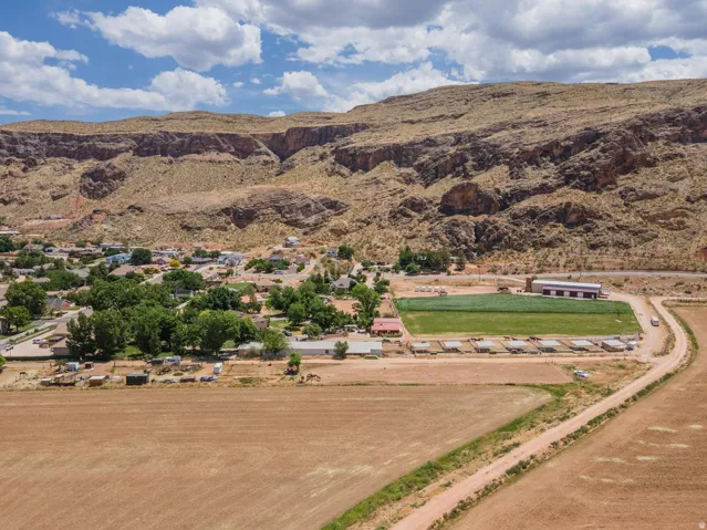 Expansive property featuring undeveloped land, established residential structures, and a prominent mountain backdrop