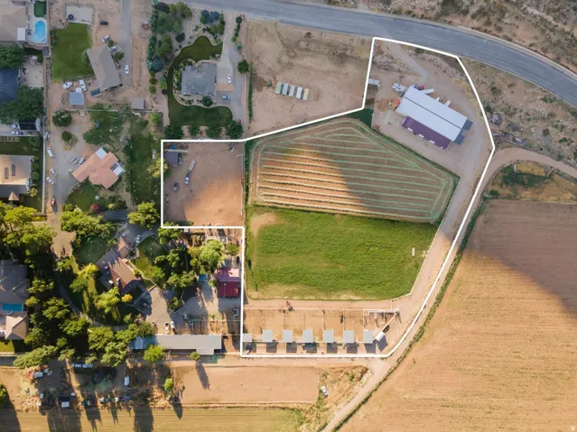 Expansive property featuring multiple cultivated fields, a large barn, and several outbuildings