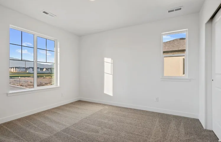 Bright room with neutral carpet, white walls, and a recessed ceiling light