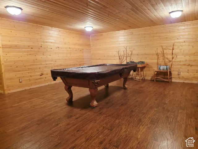 Wood-finish flooring, wood plank walls, and a wood plank ceiling with flush-mount lighting