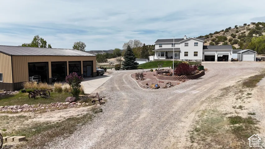 Two-story residence with attached two-car garage, additional detached two-car garage, and separate multi-bay workshop