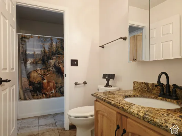 Wood-finish vanity with an integrated basin, stone countertop, and matte black faucet