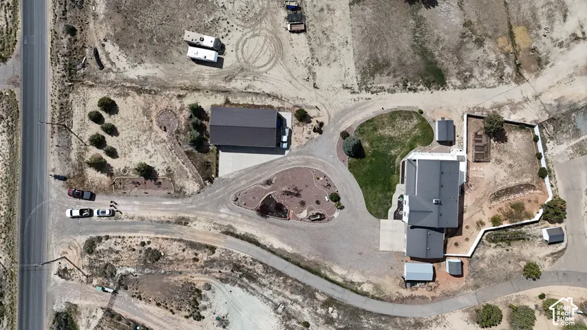Expansive property featuring a paved driveway, detached garage, and multiple outbuildings