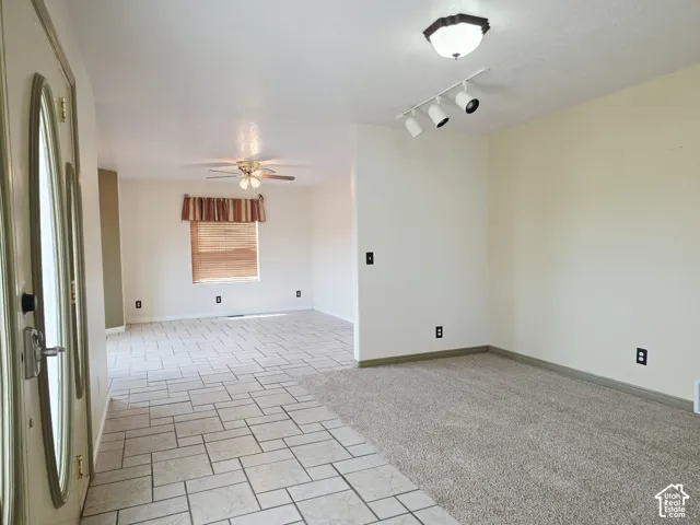 Interior featuring a combination of carpet and tile flooring, a ceiling fan, and track lighting