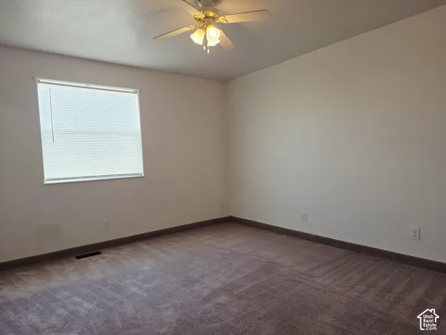 Ceiling fan with integrated lighting, window with blinds, and wall-to-wall carpeting
