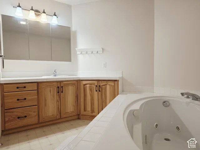 Built-in vanity with wood cabinetry, integrated sink, and white countertop