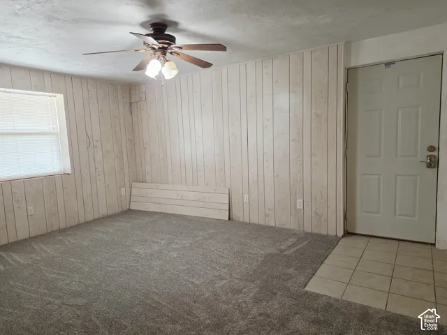 Neutral-toned paneled walls, gray patterned carpeting, and a white paneled entry door