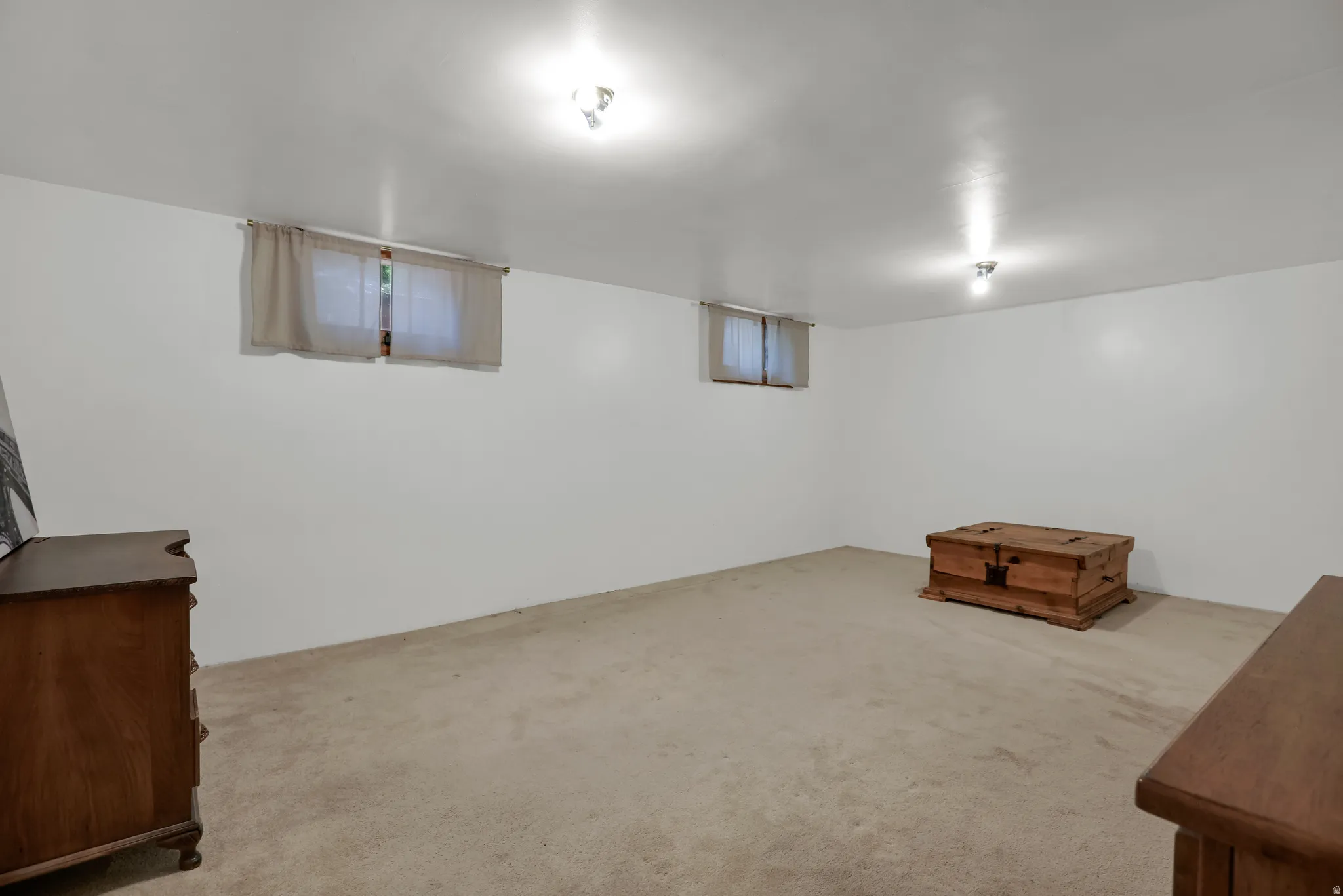Spacious room with white walls, two windows, recessed lighting, and carpeting throughout