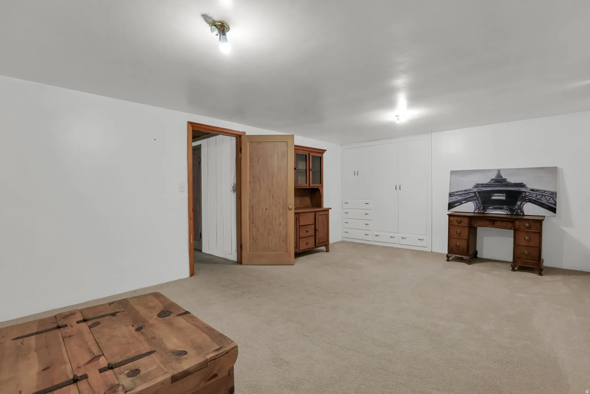 Spacious room with light neutral carpeting and white walls