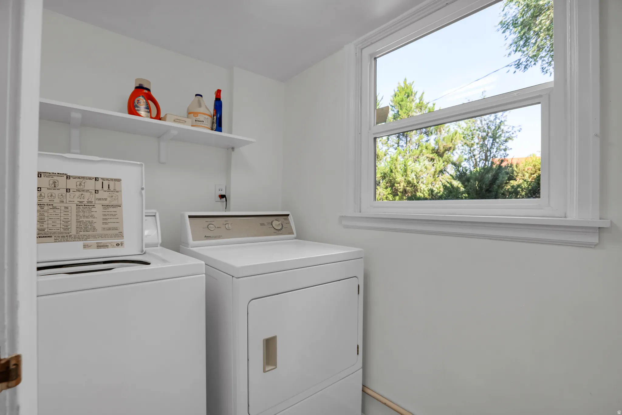Dedicated laundry space featuring a white top-load washer and front-load dryer