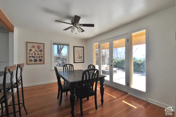 Wood-finish flooring, white walls, ceiling fan with integrated lighting, and white-framed glass paneled doors