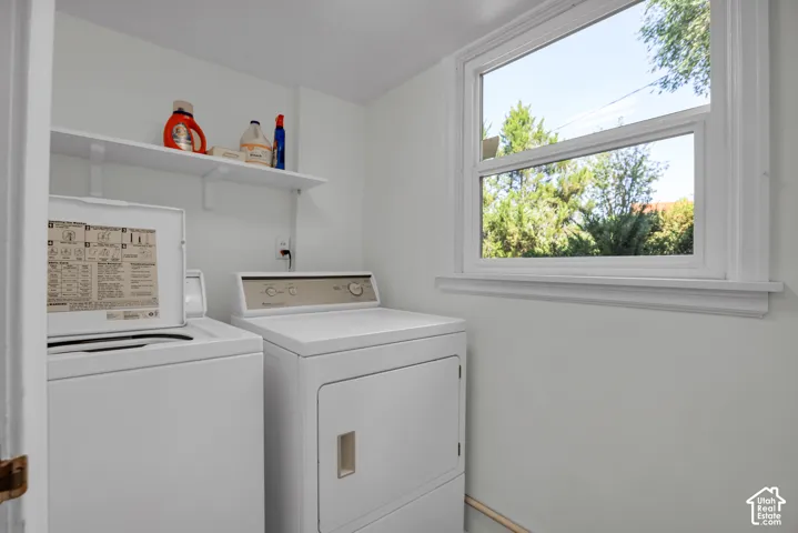 Dedicated laundry space featuring a white top-load washer and front-load dryer