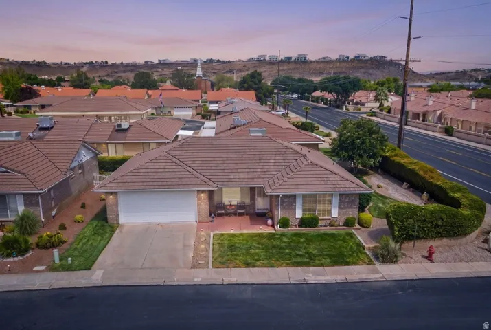 Brick facade residence featuring a tiled roof and an attached garage