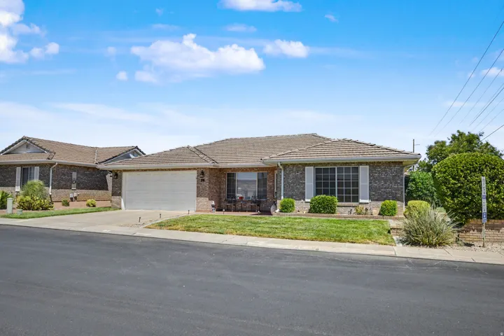 Brick exterior with tile roofing, attached two-car garage, and a concrete driveway