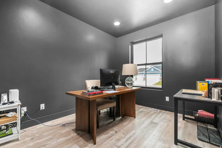 Recessed ceiling lighting, light wood-finish flooring, and a large window providing ample natural light