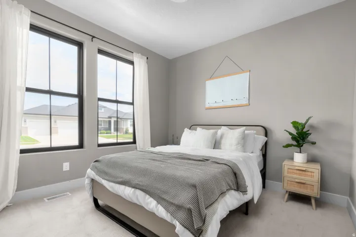 Two large multi-pane windows, light gray wall color, and light-toned carpet flooring
