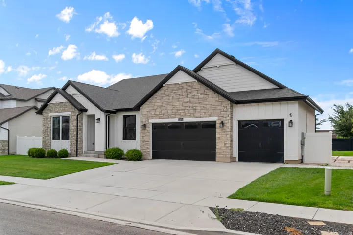 Stone and board-and-batten exterior with a dark gray shingle roof