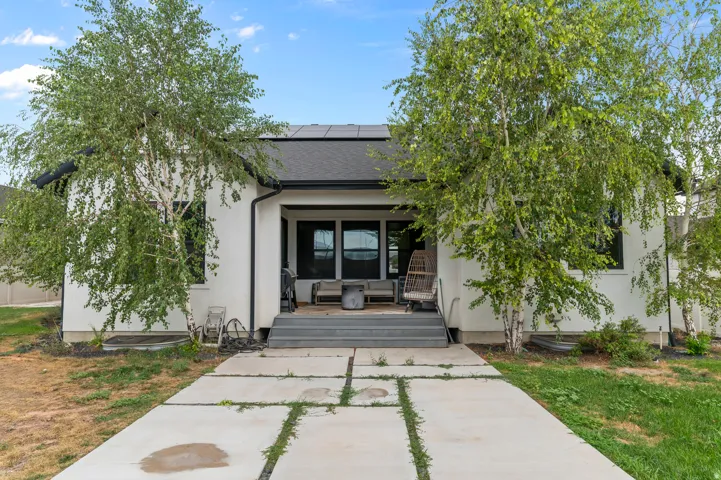 Contemporary exterior with a covered porch, dark framed windows, and a dark shingle roof