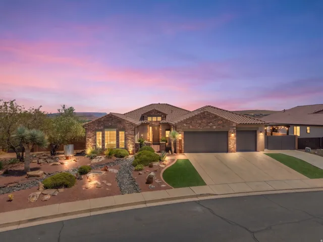 Terracotta roof tiles crown this stone and stucco residence with a two-car garage