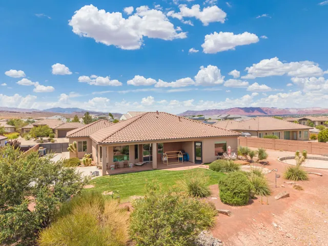 Expansive property featuring a tile roof, stucco exterior, covered patio, and a manicured lawn