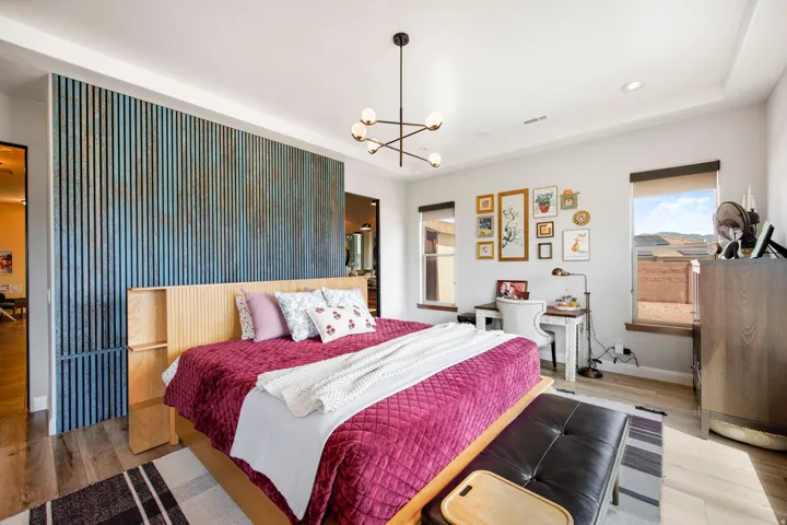 Bedroom featuring a distinctive accent wall with vertical slat detailing, wood-finish flooring, and recessed lighting